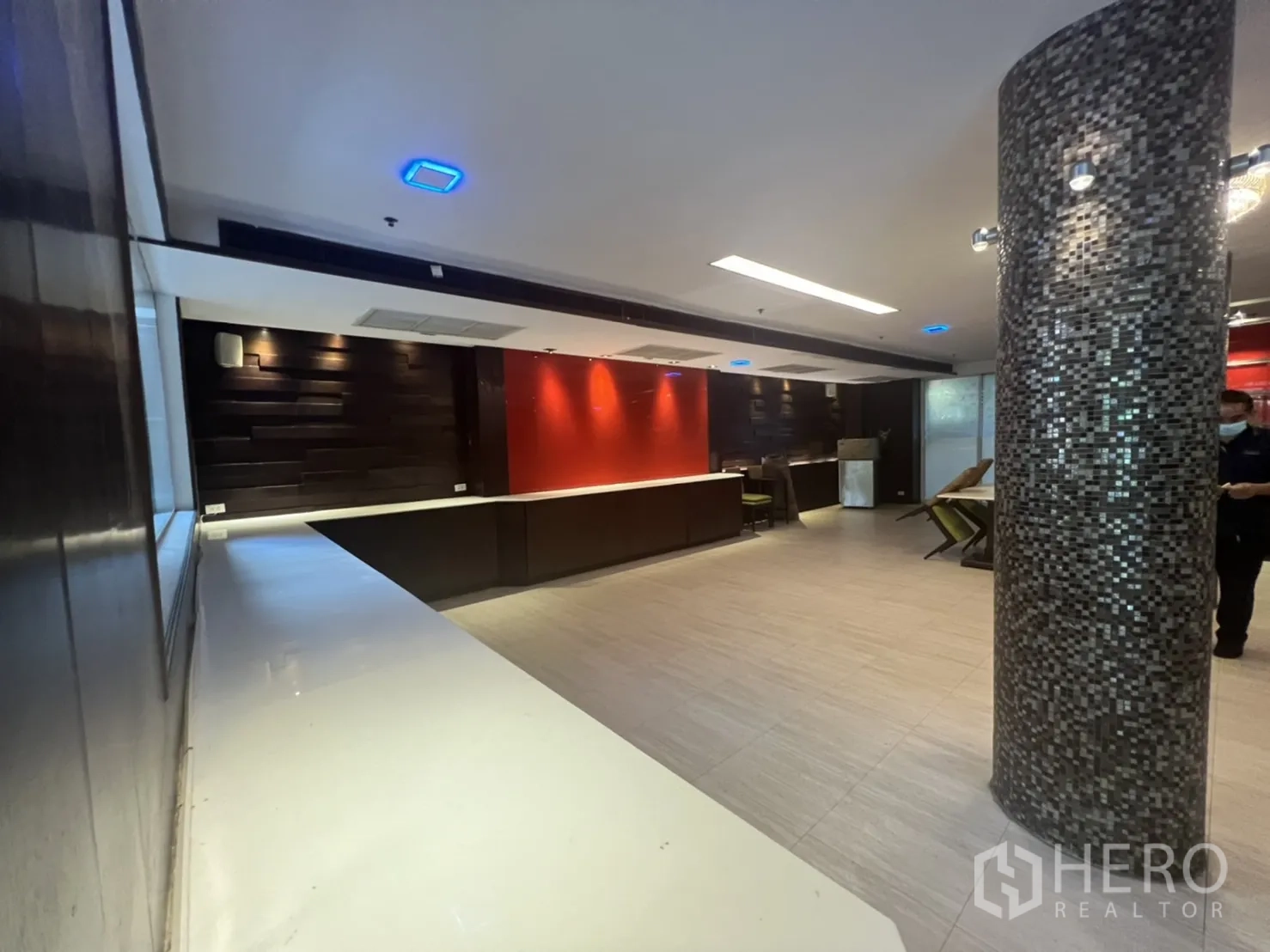 Retail Space for rent in Khlong Toei, Bangkok - Open counter and bar area with red accent wall, dark wood panels and a mosaic pillar.