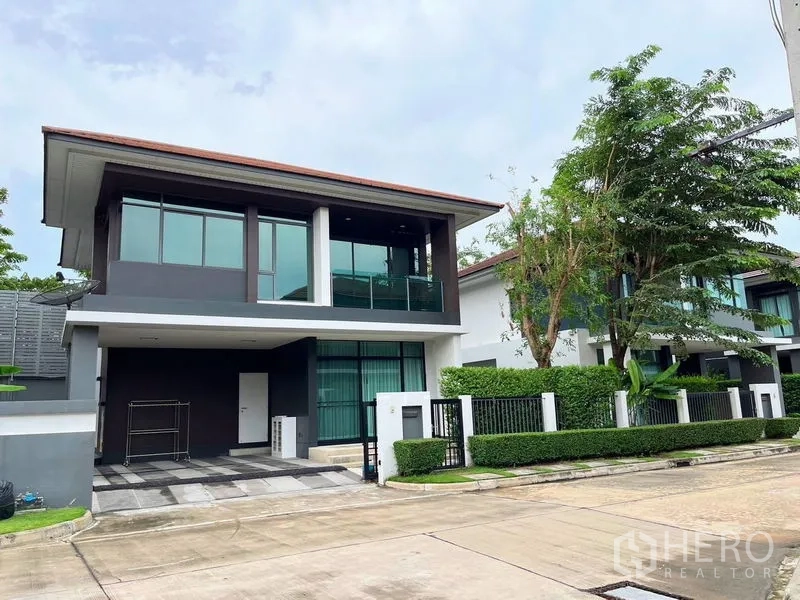 Detached House for rent in Bang Kapi, Bangkok - Two-storey modern detached house facade with driveway and landscaped hedge