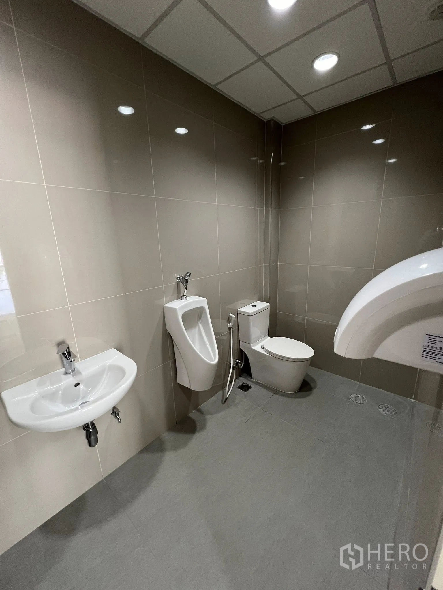 Warehouse for rent in Phra Pradaeng, Samut Prakan - Restroom with urinal, toilet, hand spray, and sink.