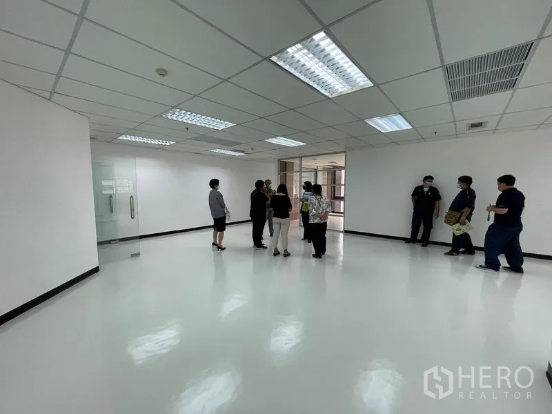 Office Space for rent in Bang Rak, Bangkok - Spacious vacant office area with glossy floors and a glass entry door.