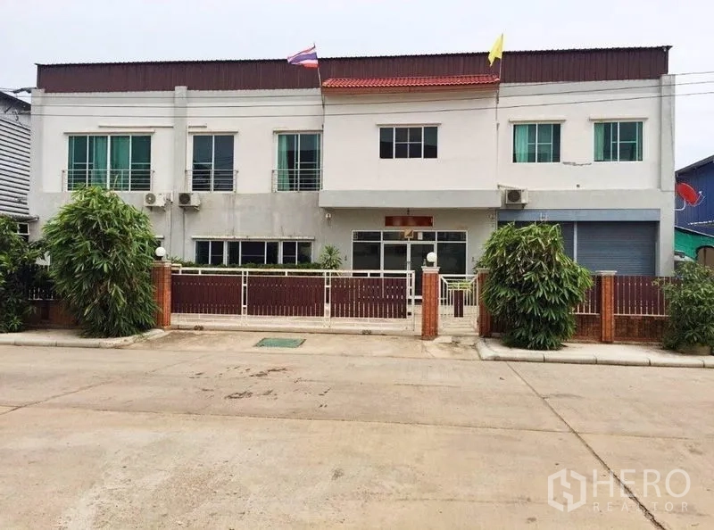 Warehouse for sale in Mueang Samut Sakhon, Samut Sakhon - Front view of a two-storey warehouse with gated entrance and parking in Mueang Samut Sakhon.