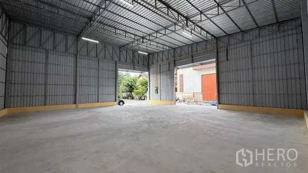 货栈 出租在Wang Thonglang, Bangkok - 仓库内部空间宽敞，高钢桁架屋顶与平整混凝土地面。