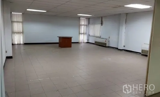 Factory for sale in Bang Phli, Samut Prakan - Empty tiled office room with windows and fluorescent lighting.