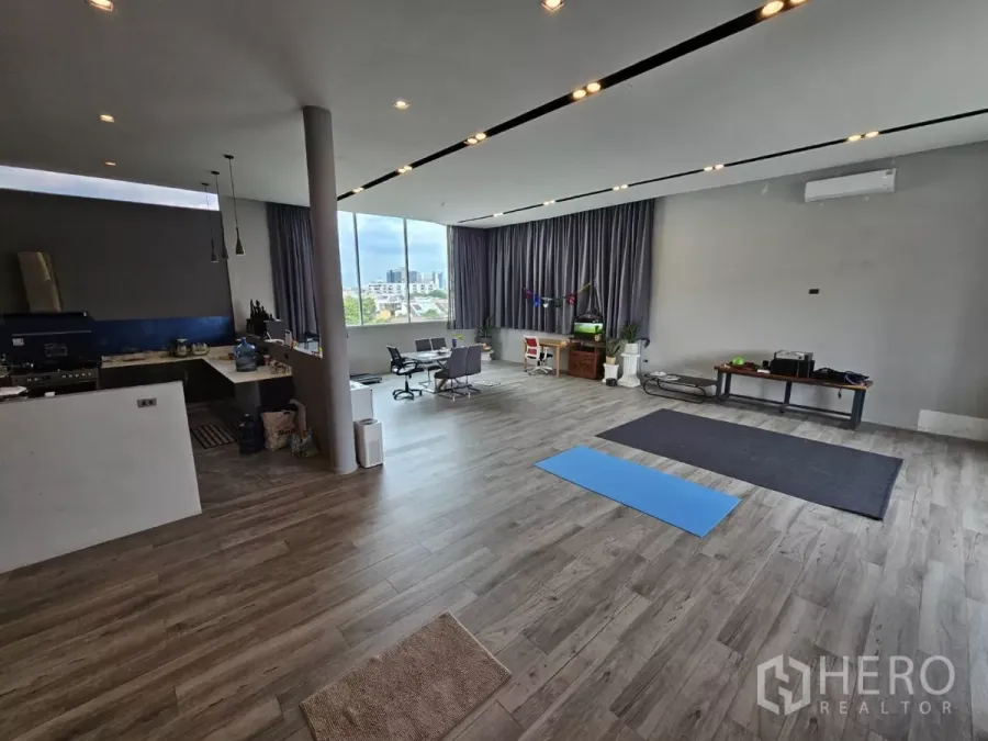 Office Space for rent - Open-plan office with wood floors, kitchenette, pendant lights and a wide window with city views.
