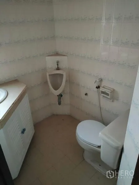 Home Office for rent in Pathum Wan, Bangkok - Compact bathroom with toilet, vanity and wall-mounted urinal.