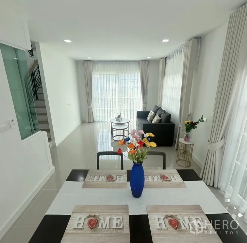 Detached House for rent in Mueang Samut Prakan, Samut Prakan - Open-plan dining and living area with full-height windows and staircase.