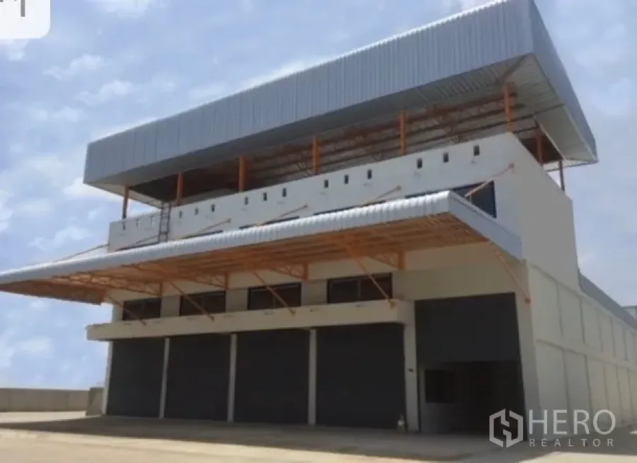 Warehouse for rent in Bang Phli, Samut Prakan - Modern warehouse exterior with multiple roller shutters and a wide loading canopy in Bang Phli.