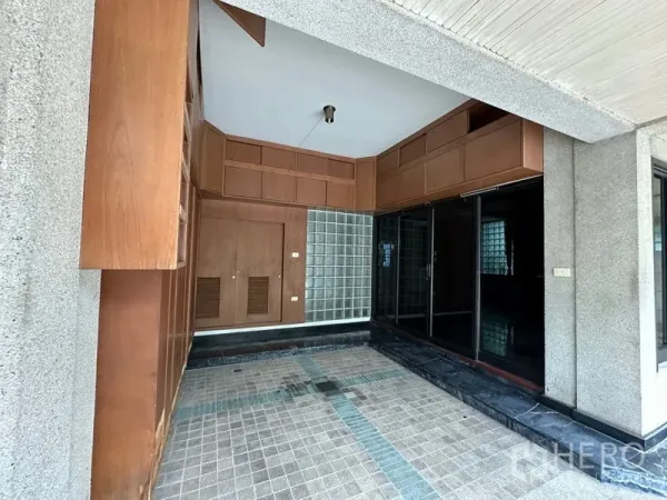 Townhouse for rent in Khlong Toei, Bangkok - Entrance foyer with built-in wood cabinets, glass-block wall and sliding doors in the Thonglor-area townhouse.