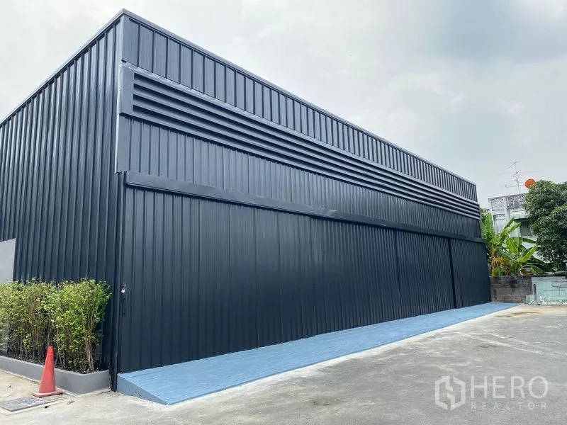 Warehouse for rent in Wang Thonglang, Bangkok - Angled exterior of corrugated metal facade with ventilation louvers and blue loading strip