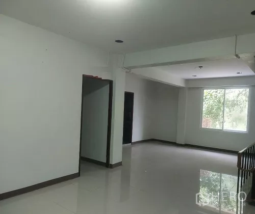 Shophouse for rent in Bang Rak, Bangkok - Open-plan level with stair landing, window light and two doorways.
