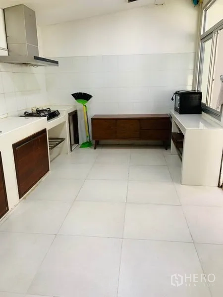 联排别墅 出租或出售在Huai Khwang, Bangkok - 简约厨房，燃气灶、排烟机、白色台面与大窗户