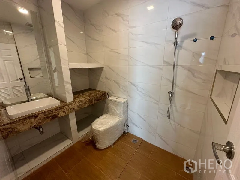 Home Office for rent in Wang Thonglang, Bangkok - Large bathroom with marble countertop, shelving, and handheld shower.