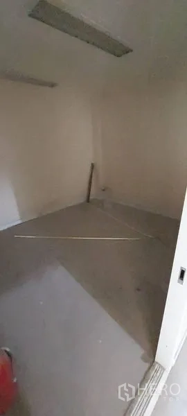 Retail Space for rent - Small dark storage room with plain walls and overhead lighting.