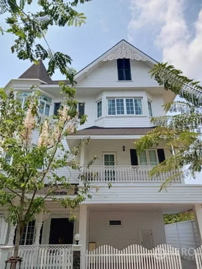Detached House for rent in Bang Na, Bangkok - Three-storey white detached house with balcony, gable trim and front trees in Bang Na.
