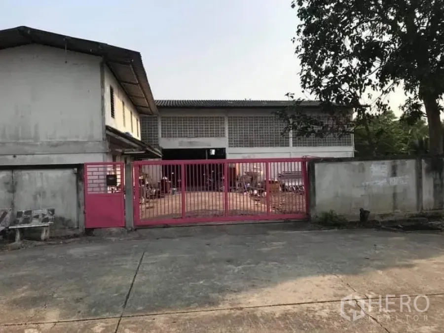 工厂 出售在Nong Chok, Bangkok - 曼谷Nong Chok工厂大门，粉色金属门与宽阔混凝土院落。