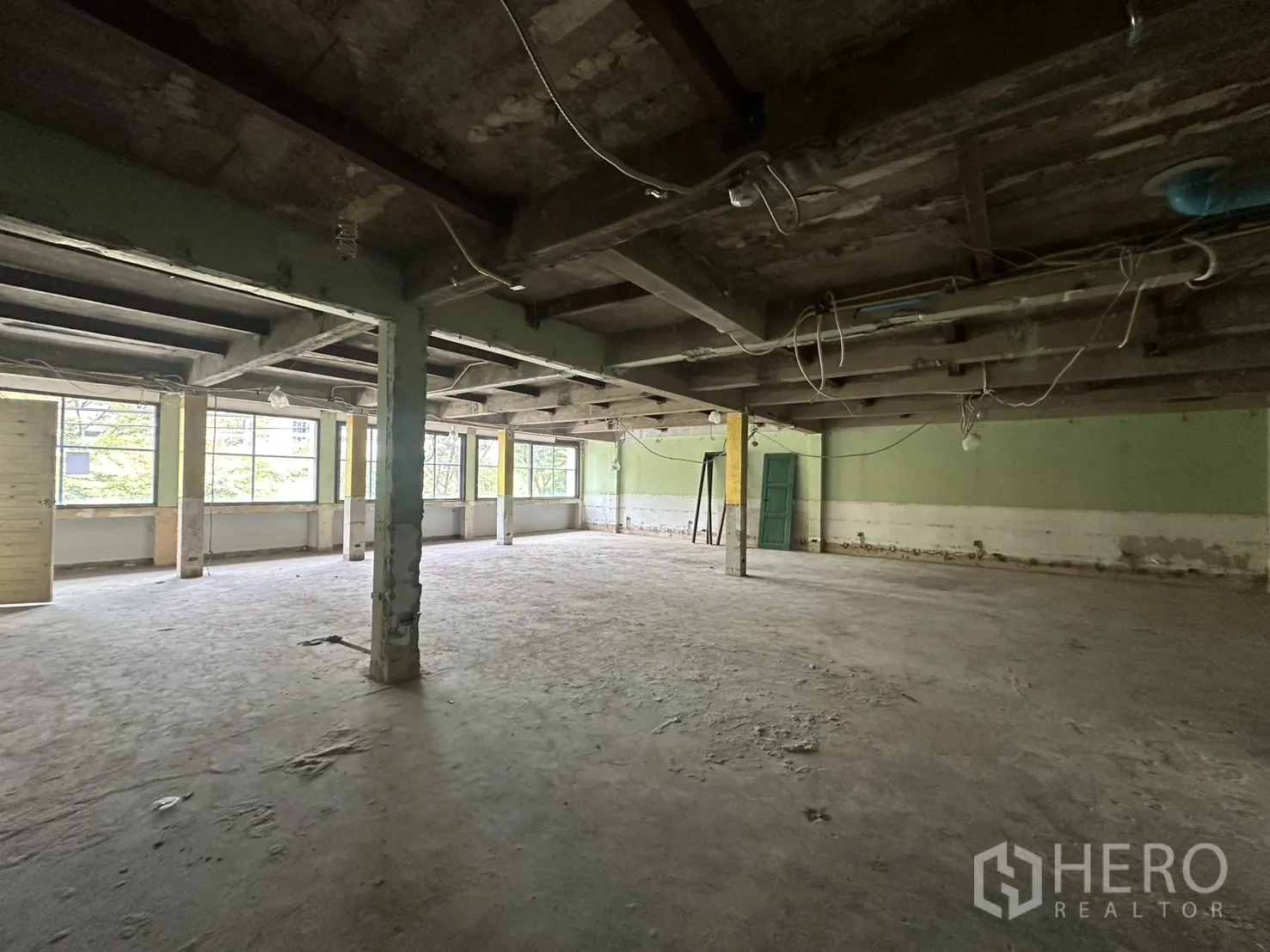 Office Space for rent in Bang Rak, Bangkok - Open-plan workspace shell with hanging cables and abundant natural light from multiple windows.