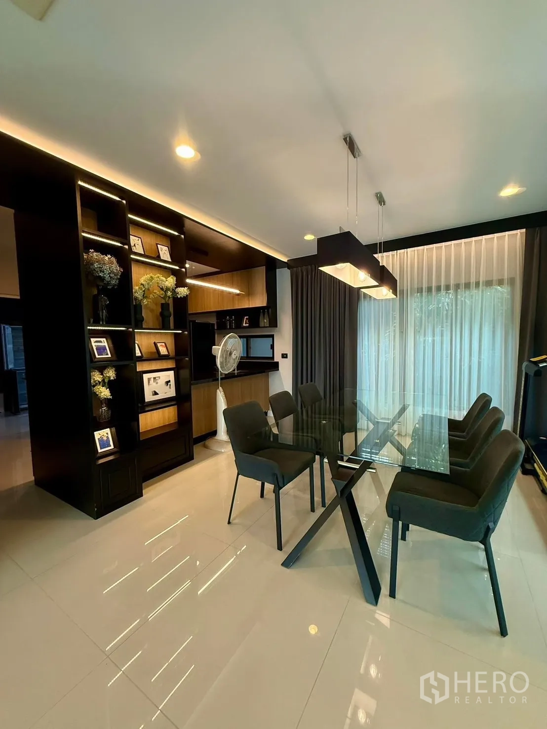 Detached House for rent in Bang Kapi, Bangkok - Dining area with glass table, six chairs and built-in display cabinetry.