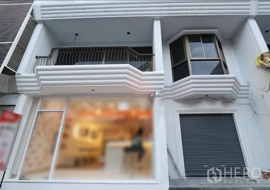Retail Space for rent in Pathum Wan, Bangkok - Street-level facade with wide glass storefront, balcony and bay window, plus a secure roller shutter.