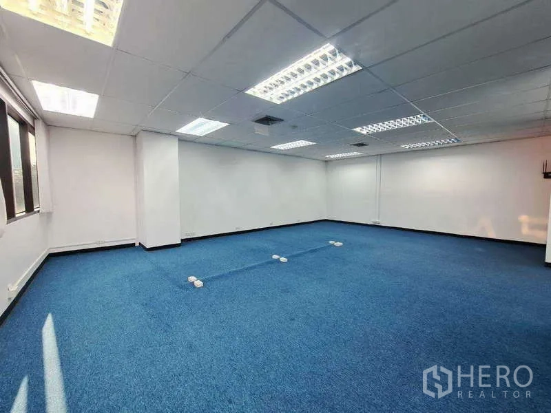 Office Space for rent in Khlong Toei, Bangkok - Open office layout with grid ceiling lights, air vents, and floor boxes for cabling.