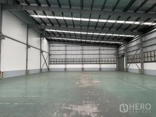 Factory for rent in Mueang Samut Prakan, Samut Prakan - Spacious warehouse hall with insulated high ceiling, skylights, and durable epoxy floor.