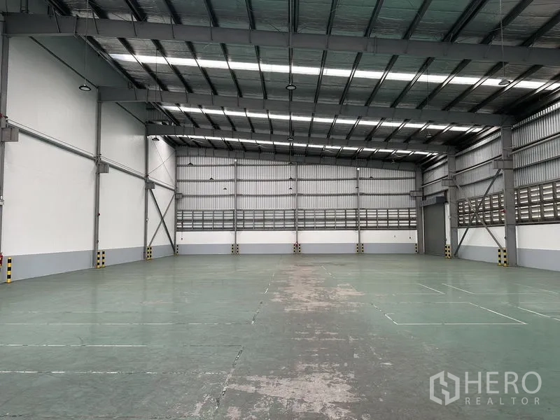 Factory for rent in Mueang Samut Prakan, Samut Prakan - Spacious warehouse hall with insulated high ceiling, skylights, and durable epoxy floor.