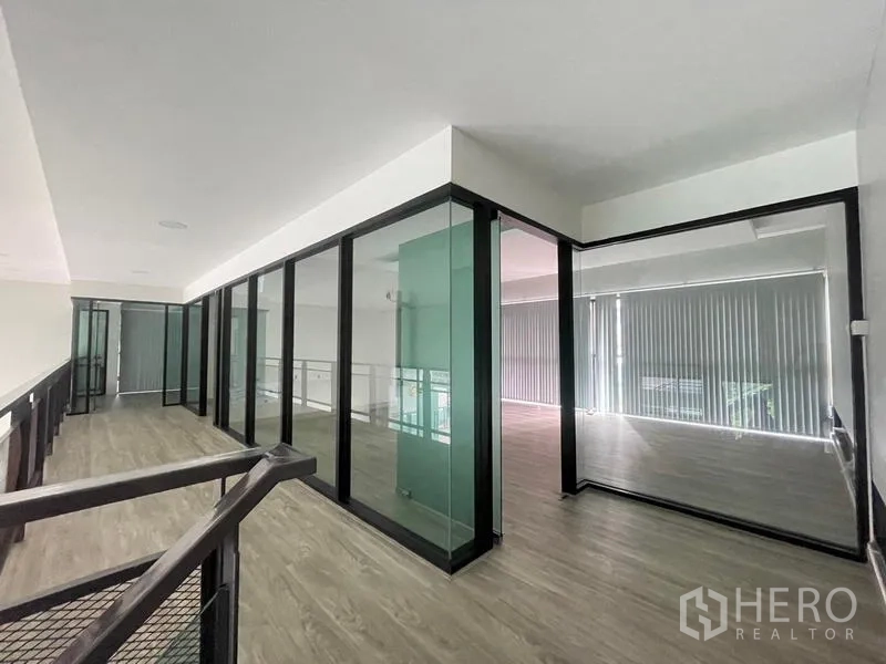 Office Space for rent in Bang Na, Bangkok - Mezzanine corridor featuring glass-partitioned meeting rooms with black frames.