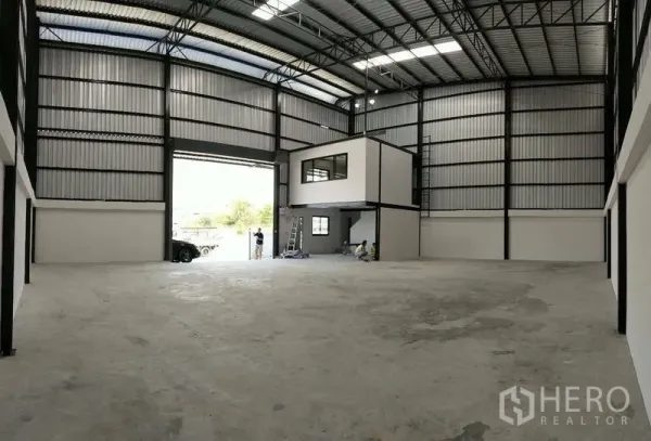 Warehouse for rent in Bang Phli, Samut Prakan - Spacious warehouse interior with high steel truss roof and mezzanine office box.