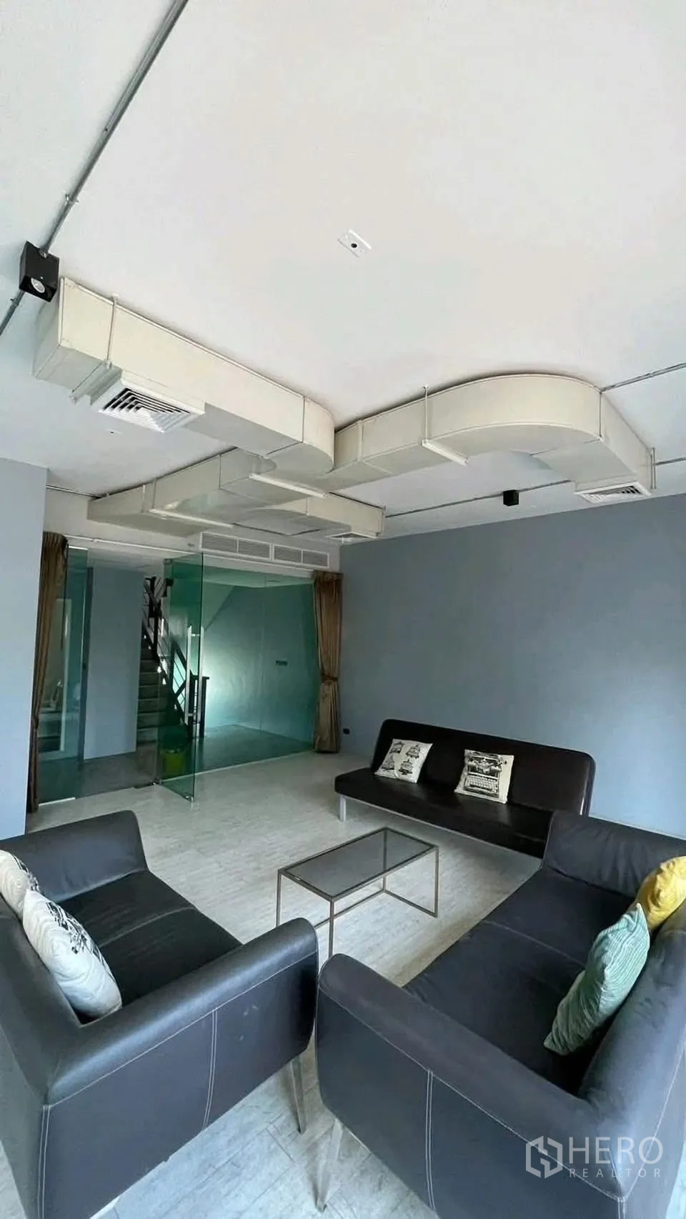 Home Office for rent or sale in Wang Thonglang, Bangkok - Sitting area with exposed ducted air-conditioning and a glass meeting room.