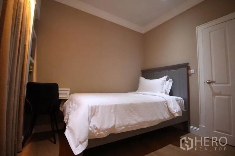Detached House for rent or sale in Lat Phrao, Bangkok - Warm-toned single bedroom with window-side study desk and simple decor.