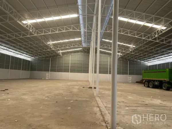 Warehouse for rent in Lat Krabang, Bangkok - Open warehouse bay with tall columns, metal cladding, and a parked green truck.