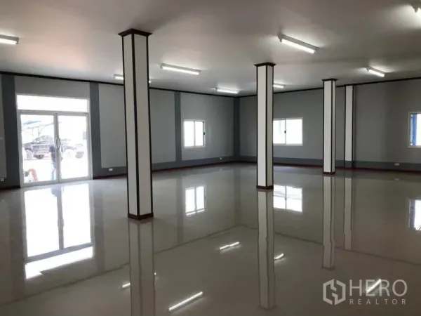 Factory for rent in Mueang Samut Sakhon, Samut Sakhon - Bright front office area with glossy floors, pillars, windows, and fluorescent lighting.