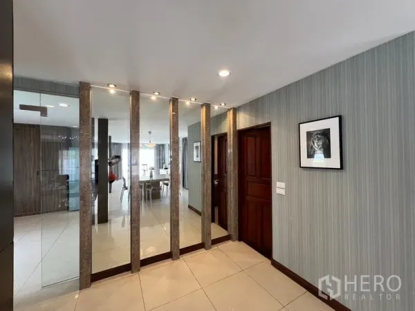 Detached House for sale in Mueang Pathum Thani, Pathum Thani - Entry hallway with mirrored wall panels, downlights and wooden interior doors.