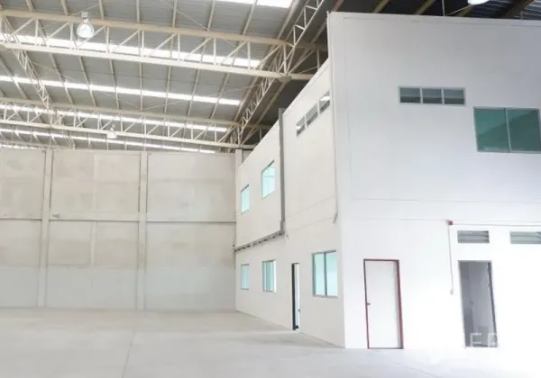 Factory for rent in Pluak Daeng, Rayong - High-ceiling warehouse interior with a two-storey built-in office, steel truss roof and polished concrete floor.