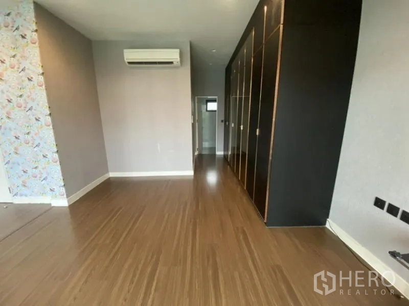 Detached House for rent in Bang Kapi, Bangkok - Bedroom walkway with built-in wardrobes and wood floors.