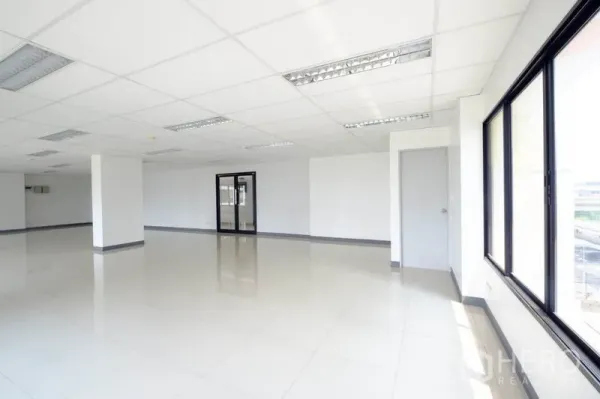 Office Space for rent in Suan Luang, Bangkok - Open office space with multiple windows, glass entry door and polished flooring.