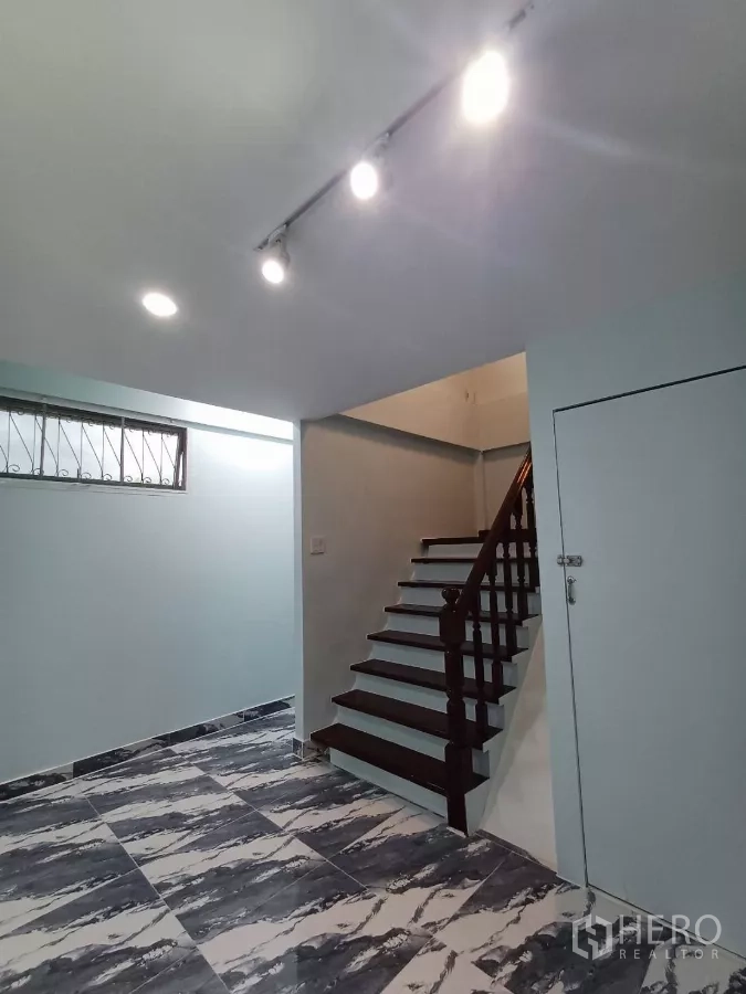 带办公室的家 出租在Phra Khanong, Bangkok - 楼梯细节，楼梯下储物柜与轨道灯。