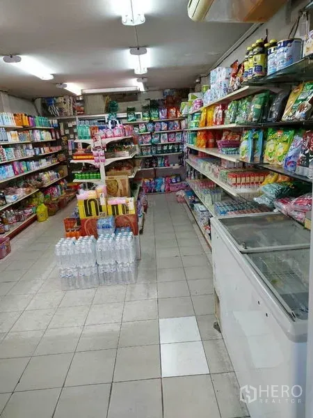 Retail Space for rent in Bang Na, Bangkok - Well‑lit retail shop interior with tiled floor, central aisle and fully stocked shelves of groceries and household goods.