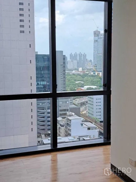Office Space for rent in Bang Rak, Bangkok - Floor-to-ceiling window view toward central Bangkok with transit lines visible below.