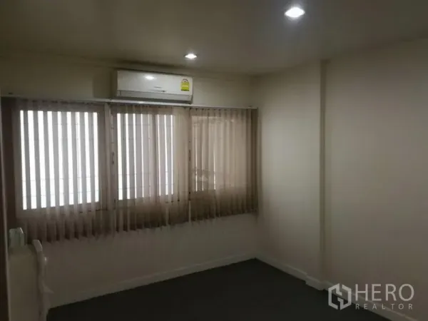 Townhouse for rent in Khlong Toei, Bangkok - Cozy bedroom with window blinds and an air-conditioning unit