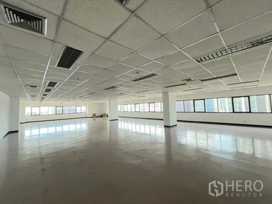 Office Space for rent or sale - Wide office floorplate with reflective flooring, columns and abundant daylight from wraparound windows.