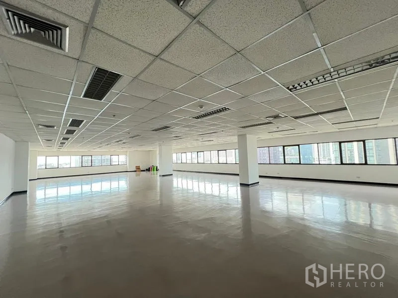 Office Space for rent or sale - Wide office floorplate with reflective flooring, columns and abundant daylight from wraparound windows.