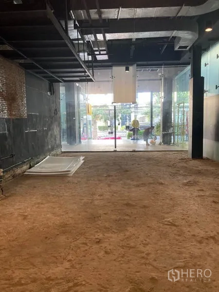 Retail Space for rent in Watthana, Bangkok - Open-shell retail unit with high ceiling and full-height glass storefront facing the street.