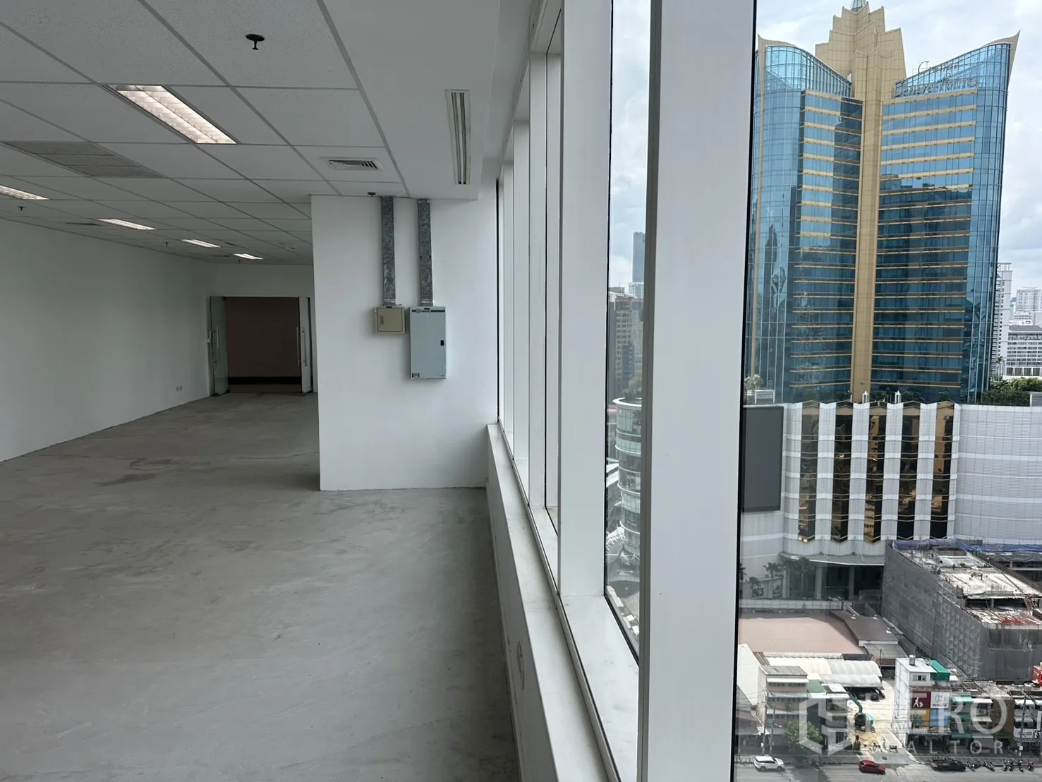 Office Space for rent in Watthana, Bangkok - Window-lined workspace corridor showing high-rise buildings outside.