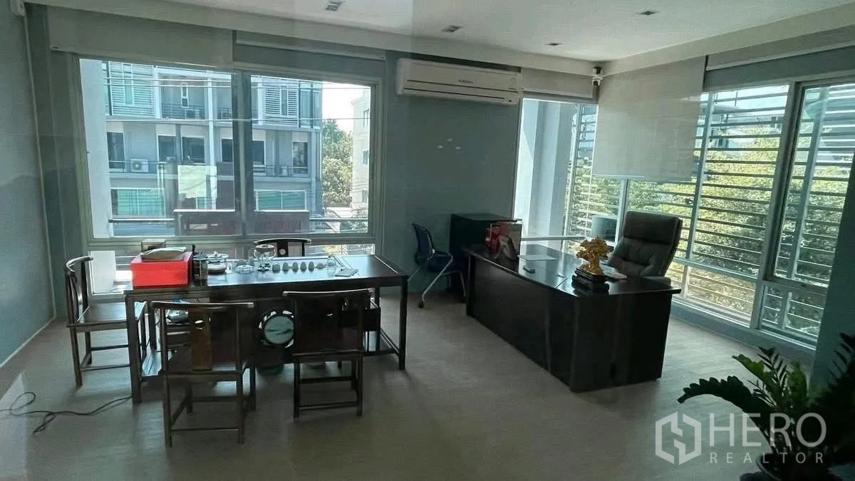 Home Office for rent or sale in Wang Thonglang, Bangkok - Executive office with a desk, meeting table, and wide windows.
