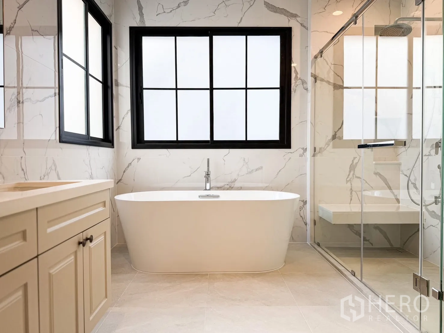 Detached House for rent in Bang Khen, Bangkok - Bathroom view showing soaking tub, glass-enclosed rain shower and marble-look tiles.