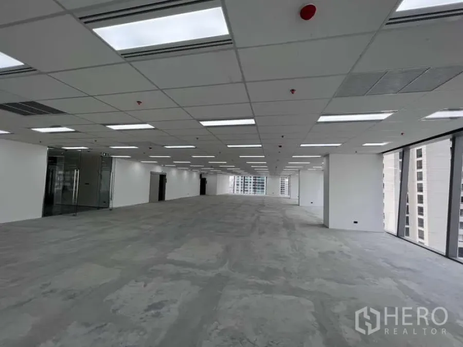 Office Space for rent - Open-plan 400 sqm office floor with drop ceiling LED lights, glass entry, and floor-to-ceiling windows offering city views in Ploenchit.