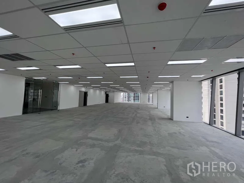 Office Space for rent - Open-plan 400 sqm office floor with drop ceiling LED lights, glass entry, and floor-to-ceiling windows offering city views in Ploenchit.