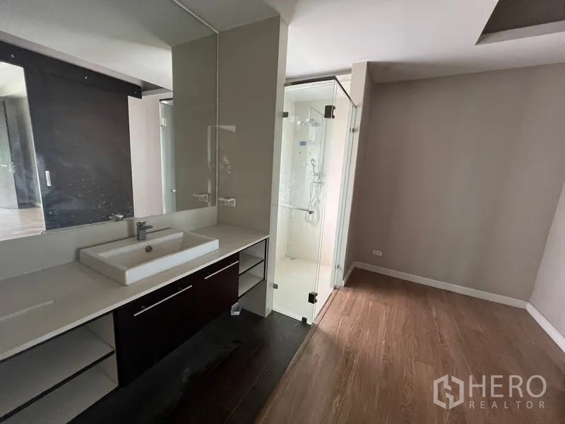 Townhouse for rent or sale in Khlong Toei, Bangkok - Bedroom vanity and a glass-enclosed shower in the ensuite bathroom.