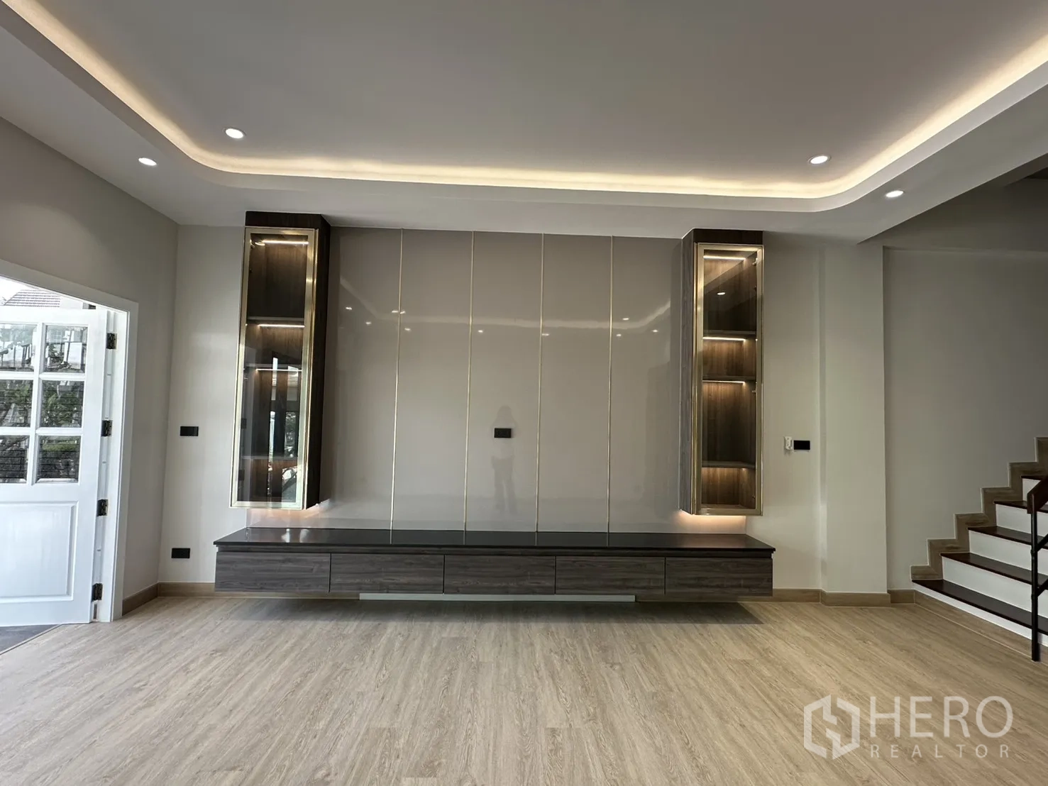 Home Office for rent in Watthana, Bangkok - Living room with custom TV wall and floating cabinets under soft lighting.