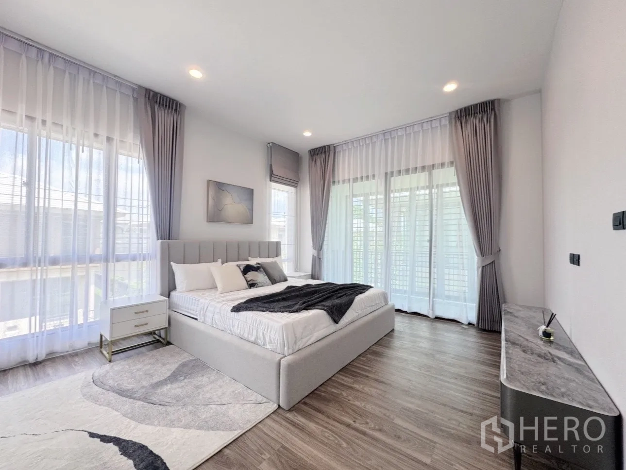 Detached House for rent or sale in Bang Kapi, Bangkok - Spacious master bedroom with king bed, wide windows and wood flooring.